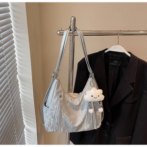 Detail of silver pleated Hobo bag with metallic finish and white plush cloud charm