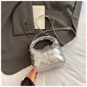 Détail du sac hobo tressé argenté montrant la texture métallique et le cuir croisé