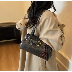 Close-up of retro brown shoulder bag with metal buckles and abacus charm detail
