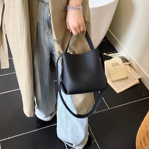 Sac seau minimaliste en cuir noir avec poignée et bandoulière pour un usage quotidien
