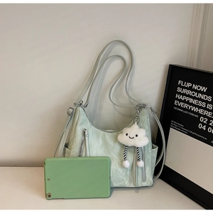 Detail of mint green hobo bag with pleated texture and plush cloud charm accessory
