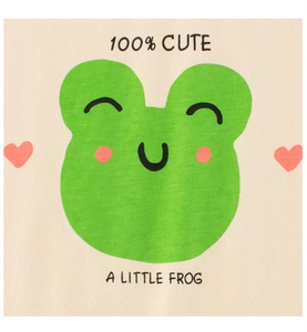 Detail of baby t-shirt with 100% CUTE text and cartoon frog print on beige fabric