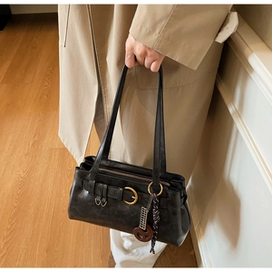 Close-up of black retro leather handbag with gold hardware and striped ribbon detail