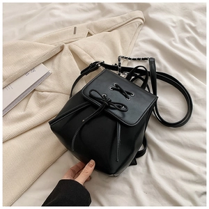 Detailansicht eines schwarzen PU-Mini-Rucksacks mit Schleife und silbernen Ketten