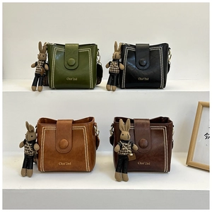 Close-up of retro crossbody bucket bags in four colors with cute rabbit charms