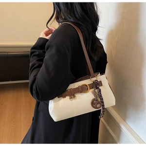 Detail of retro leather shoulder bag with dark brown contrast and pretzel charm