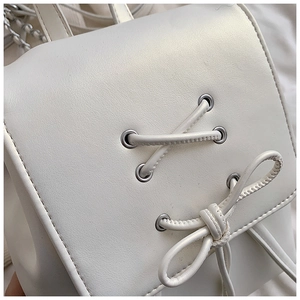 Nahaufnahme der weißen PU-Ledertasche mit Metallösen und Schleifen-Schnürung