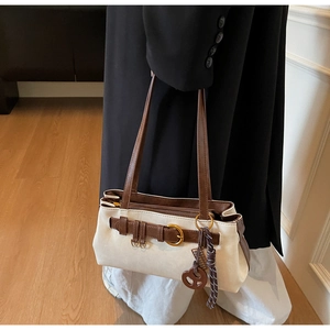 Close-up of contrast retro pillow bag featuring gold buckle and peace sign charm