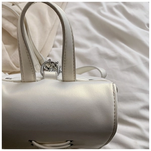 Nahaufnahme der weißen Handtasche mit Ledertextur und silbernen Metallteilen
