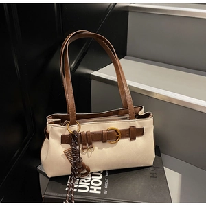 Detail of off-white retro pillow bag with brown straps and vintage gold hardware