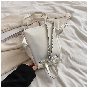 Details einer weißen minimalistischen PU-Lederhandtasche mit Seitenflügeln und Silberkette
