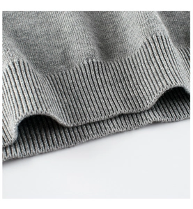 Detail of grey knitted sweater ribbed hem showing high-quality fabric texture
