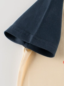 Detail of raglan sleeve cuffs on kids short sleeve T-shirt with navy contrast stitching