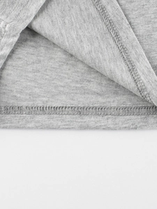 Gros plan de l'ourlet d'un t-shirt gris clair pour enfant avec double couture soignée