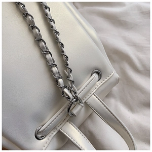 Details einer perlweißen Leder-Beuteltasche mit silberner Kette und Metallösen-Verschluss