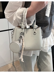 Borsa a secchiello in pelle martellata con manico intrecciato e piccolo portamonete