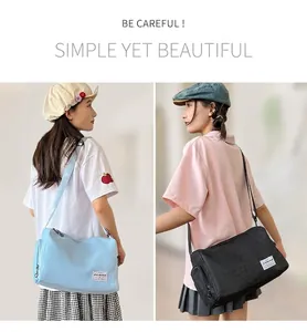 Detail of adjustable wide shoulder strap and brand label on canvas crossbody bag