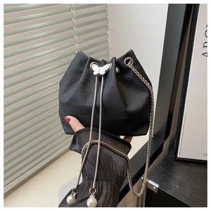 Detail of black crocodile pattern bucket bag with silver butterfly clasp and pearl charms