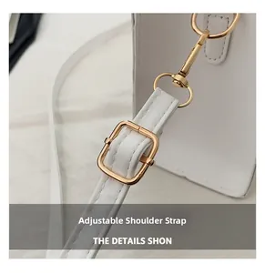 Detail of adjustable leather strap with light gold buckle on white crossbody bag