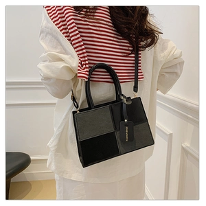 Detail view of a color-block square crossbody bag with chess pattern and logo tag