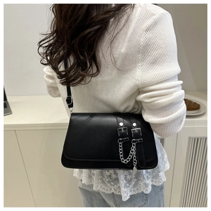 Chic black underarm bag with double silver buckles and metal chain strap on a model