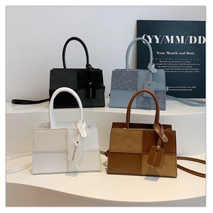 Collection of color-block handbags in black, blue, white, and brown on white pedestals