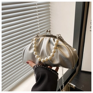 Close-up of silver pleated bag with pearl handle and metallic finish chain strap