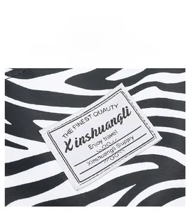 Detail of water-resistant zebra pattern oxford fabric with branded woven travel label