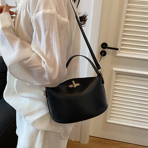 Minimalist black matte leather bucket bag with gold clasp and versatile straps for women