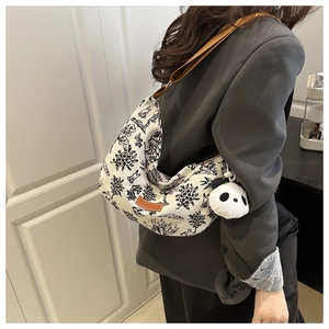Canvas crescent tote bag with vintage rabbit print and plush panda charm on shoulder