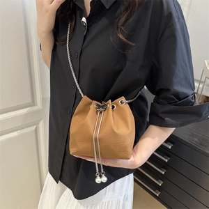 Brown croc-effect bucket bag with butterfly detail and pearl drawstring strap