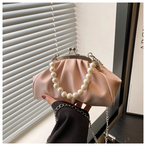 Detail of pink pleated clutch featuring large pearl handle and vintage metal clasp
