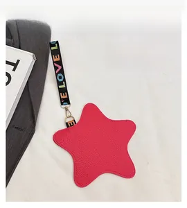 Detail of star-shaped rose red coin purse with textured leather and rainbow strap