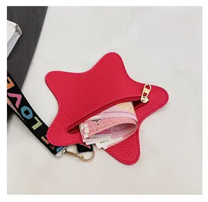 Detail of star-shaped coin purse with litchi texture and LOVE strap showing inner capacity