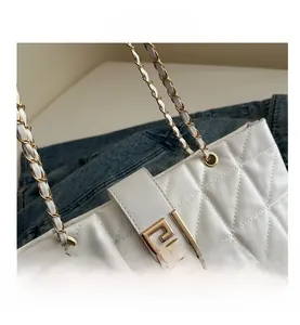 Detail of white quilted leather bag with geometric gold chain and metallic buckle