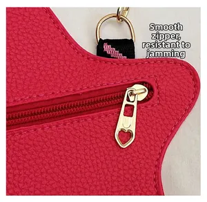 Detail of fuchsia litchi leather bag showing smooth golden heart-shaped zipper and strap