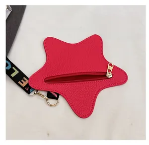 Close-up of a red star-shaped coin purse with gold zipper and woven letter strap