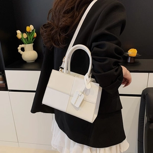 Retro contrast color shoulder bag with top handle shown from a side view on a model