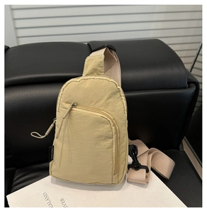 Detail of light beige water-repellent nylon crossbody bag with multi-zipper compartments