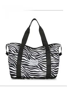 Macro view of zebra pattern travel tote showing the reinforced straps and bottom zipper