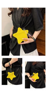 Detail of yellow star-shaped clutch bag with lychee grain leather and LOVE wrist strap