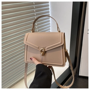 Vue détaillée du sac à main beige en similicuir avec fermoir rotatif doré et texture lisse