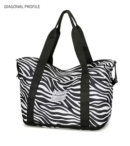 Détail d'un grand sac de voyage zébré avec des anses en nylon et une fermeture éclair