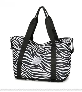 Detail view of large zebra print travel tote bag with durable nylon straps and zipper