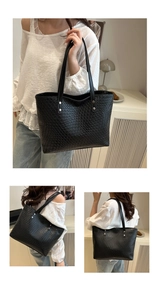 Detail of black woven leather tote bag showing shoulder straps and large capacity design