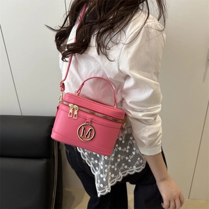 Pink retro box handbag with golden M logo and dual zippers for stylish women