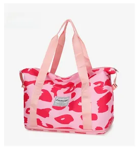 Detailed view of pink camouflage travel bag with water-resistant fabric and woven label