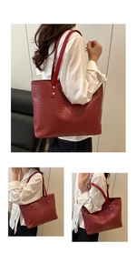 Close-up of red woven leather tote bag with large capacity and silver rivet details