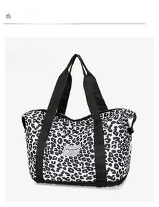 Detail of cow print oxford bag featuring bottom shoe compartment and brand label