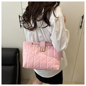 Detail of pink quilted leather shoulder bag with gold geometric buckle and chain strap